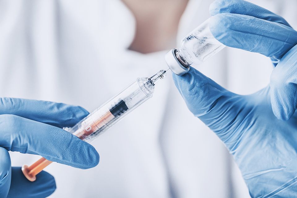 Doctor holding syringe.